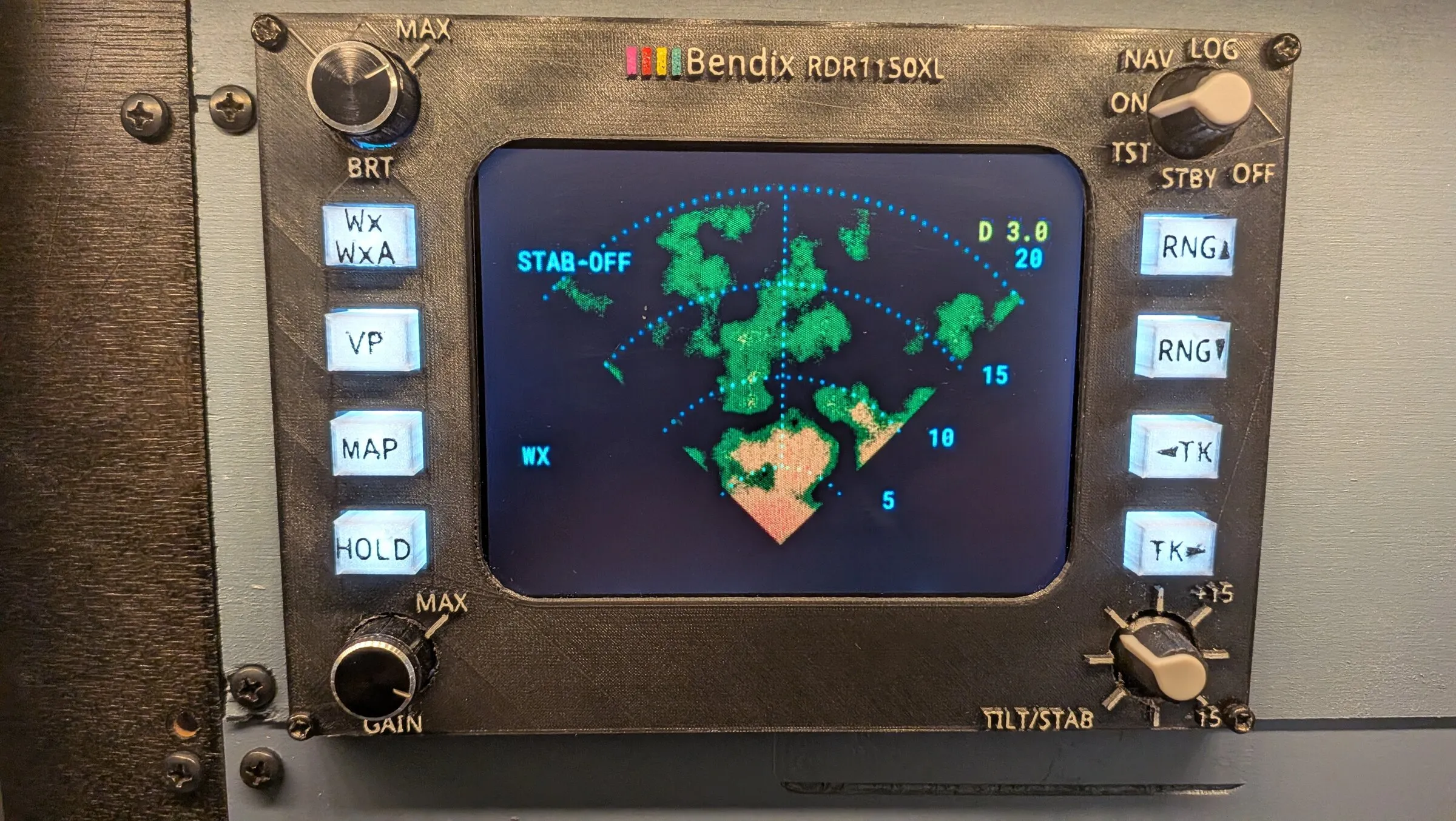 The weather radar replica mounted in a panel, showing green and red storm cells with range rings